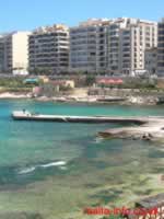 Pier into St Julian's Bay. The background shows the cafe & fountaint